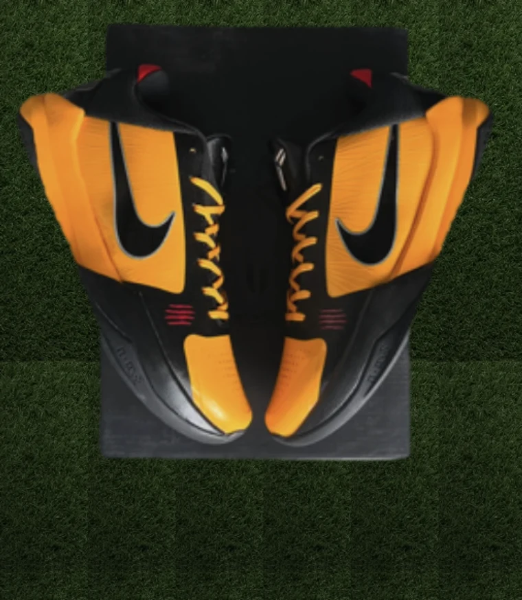 Orange and black Nike high-top sneakers on turf