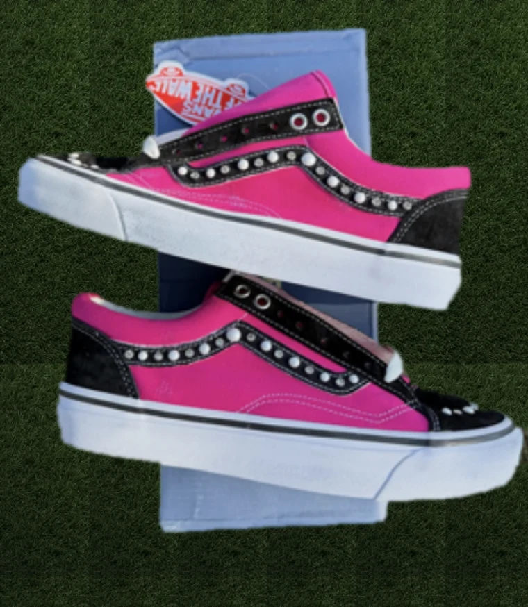 Pink studded Vans sneakers on turf